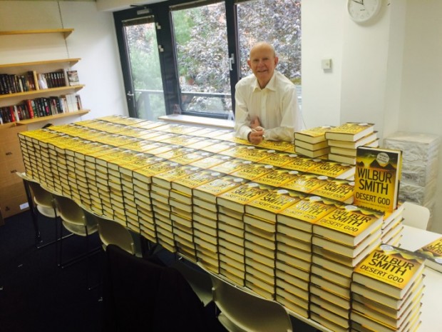 Wilbur Smith Posing With his Books